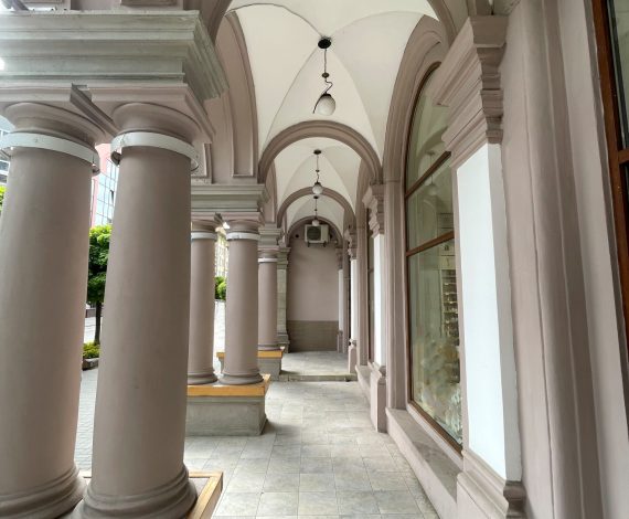 Arches and columns of an ancient building in the central part of the city on a cool summer morning. Background for your needs